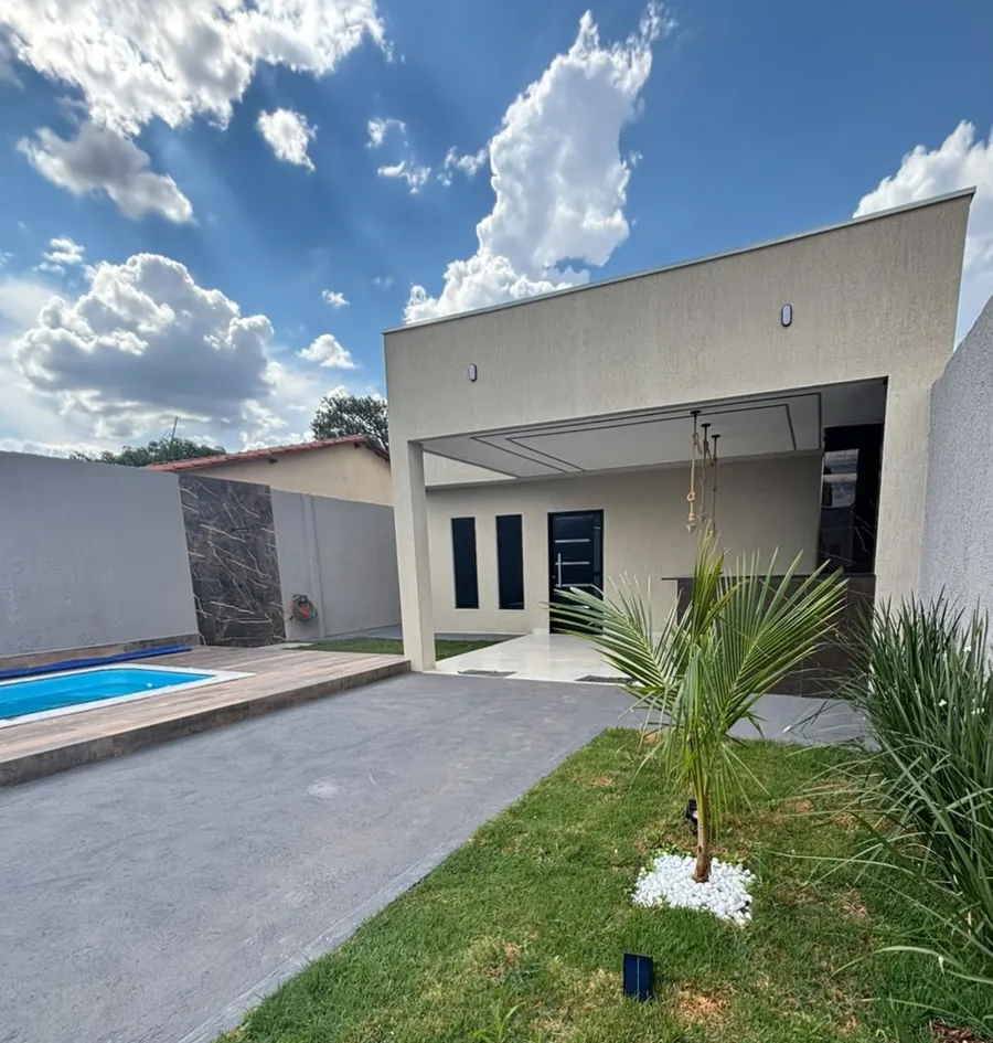 Fachada moderna da casa, com jardim, uma palmeira e a piscina ao fundo