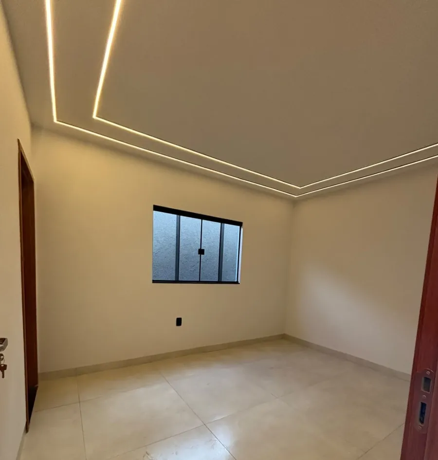 Quarto com iluminação em perfil de LED no teto e janela