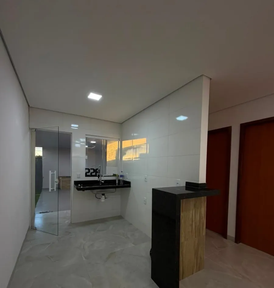 Cozinha americana com bancada de granito e porta de vidro