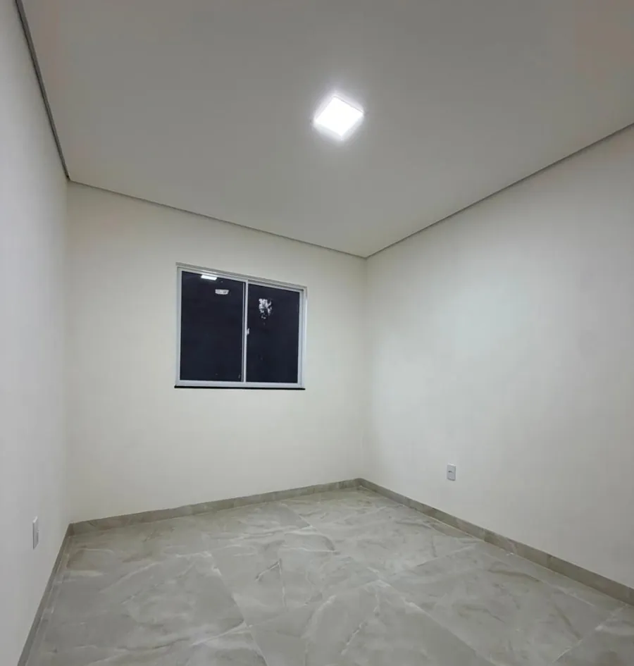 Quarto com janela de vidro escuro na parede do fundo