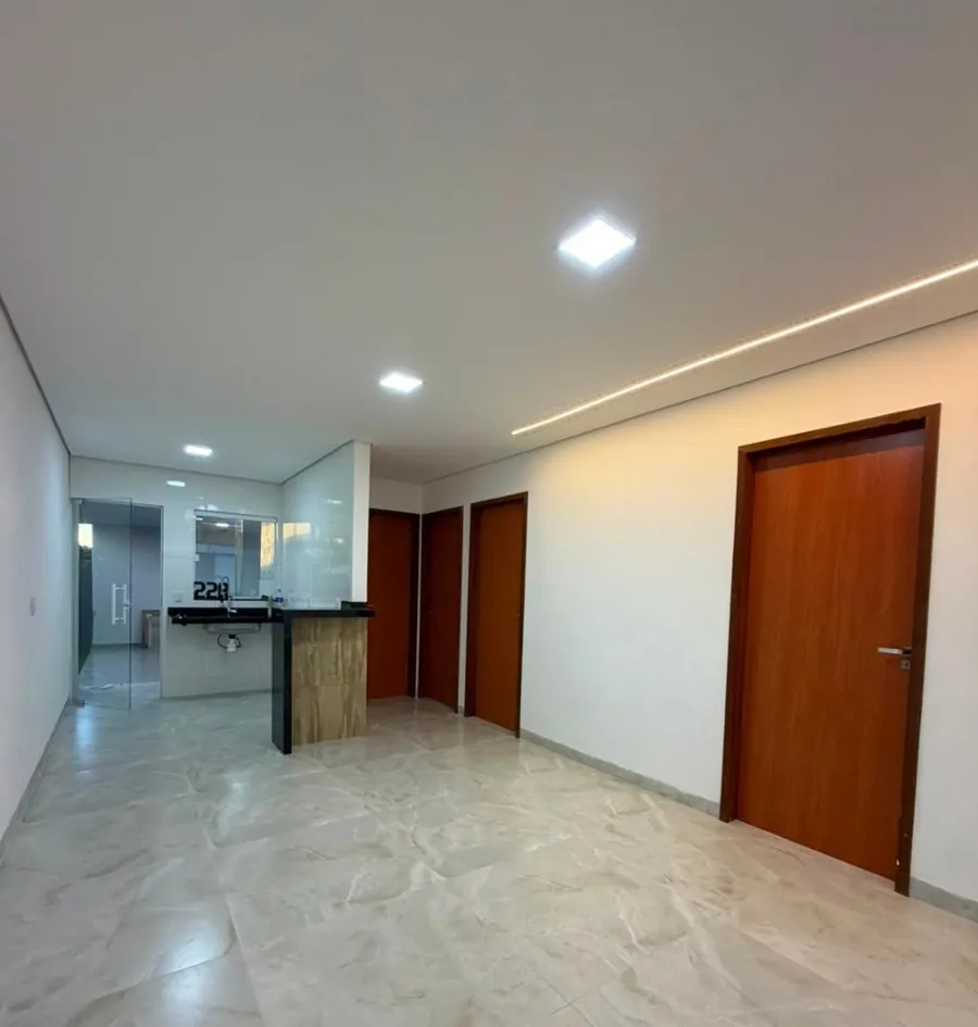 Sala ampla integrada à cozinha, com iluminação em perfil de LED no teto